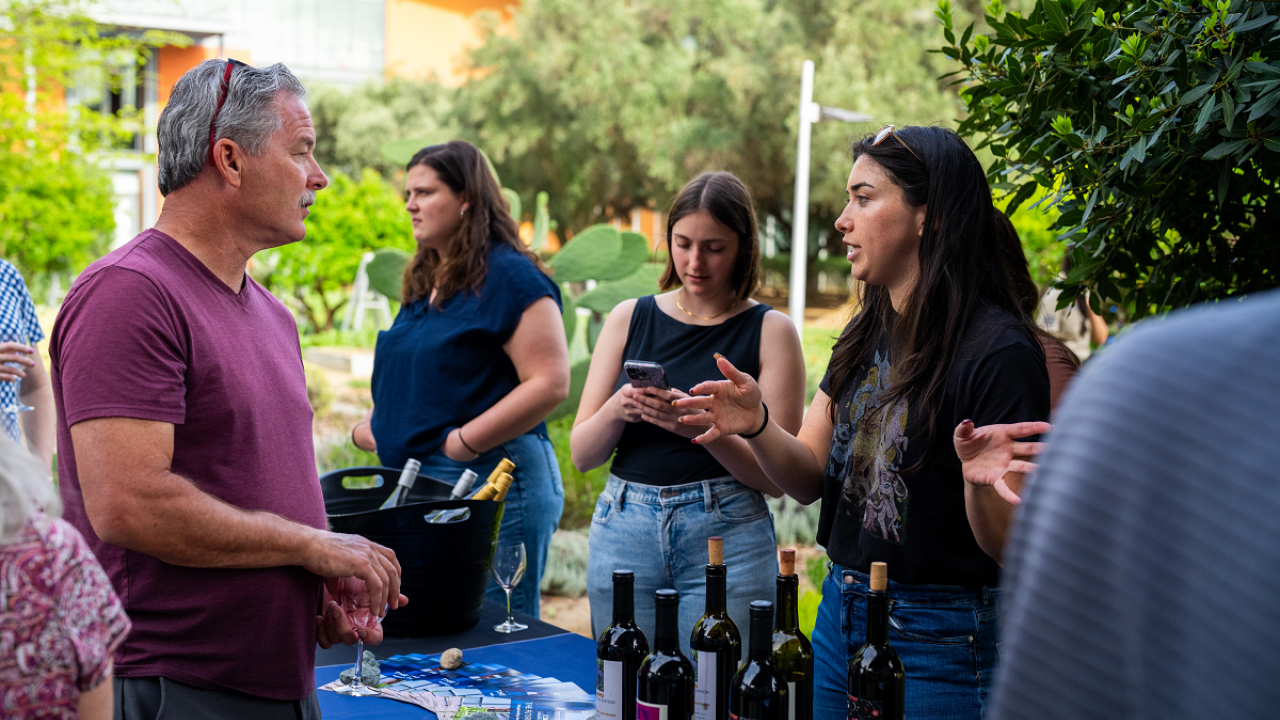 Students pouring wine for guests