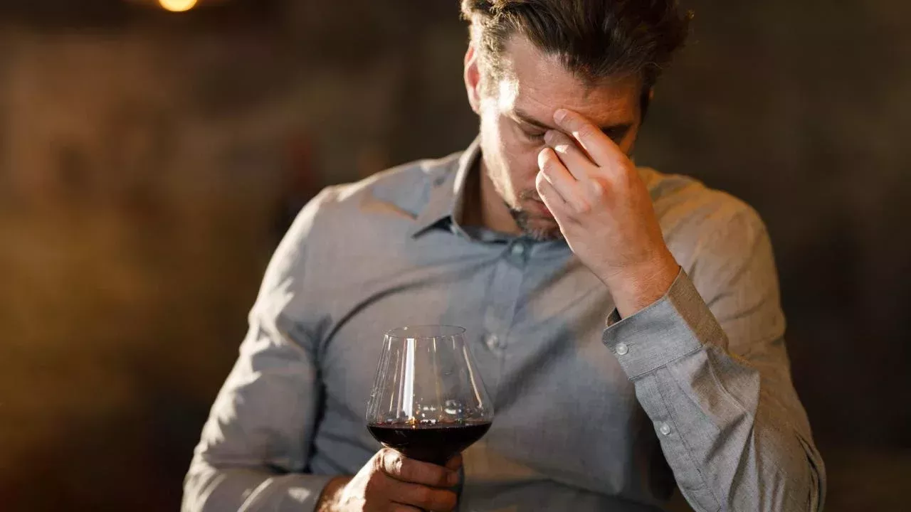 Man rubbing his forehead while drinking red wine. UC Davis scientists theorize that a flavanol found naturally in red wine can interfere with the metabolism of alcohol and cause "red wine headache." (Getty) UC Davis scientists theorize that a flavanol found naturally in red wine can interfere with the metabolism of alcohol and cause a “red wine headache.” (Getty)