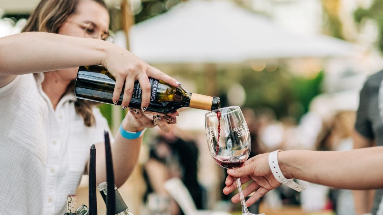 Person pouring wine into someones glass
