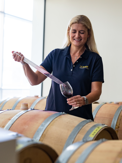 Anita Oberholster extracting wine from a cask